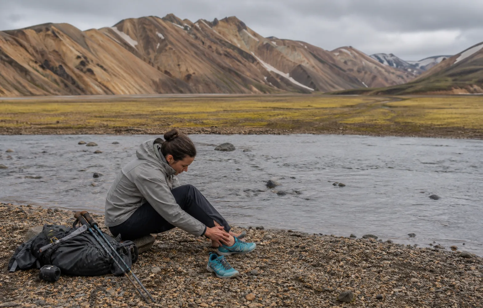 Hikers changing into secure river shoes before a crossing on Iceland’s Laugavegur Trail.